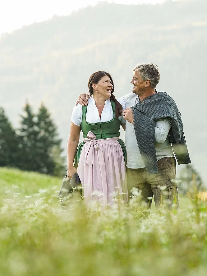 Gastgeber & Geschichte Jacky und Toni Hasenauer auf einer Wiese im Hotel Unterschwarzachhof