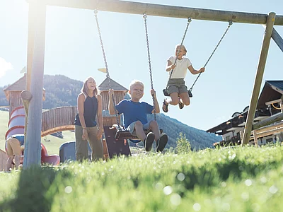 Kinder schaukeln beim Hotel Unterschwarzachhof in Saalbach Hinterglemm