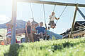 Children on the swings at the Hotel Unterschwarzachhof in Saalbach Hinterglemm