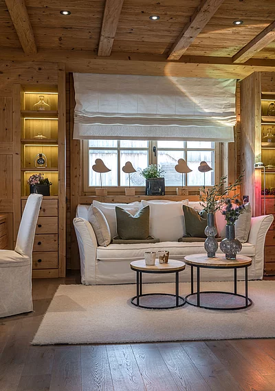 Stilvoller Wohnbereich mit Schreibtisch, Sofa und Holzvertäfelung im Chalet.