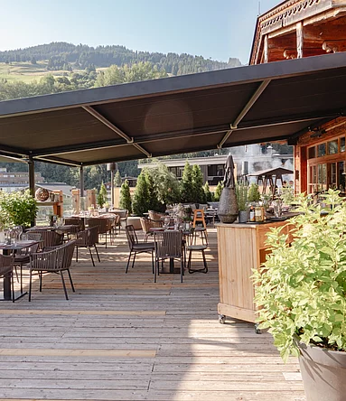 überdachte Terrasse mit Bergen im Hintergrund beim BBQ Grillabend Unterschwarzachhof Saalbach Hinterglemm