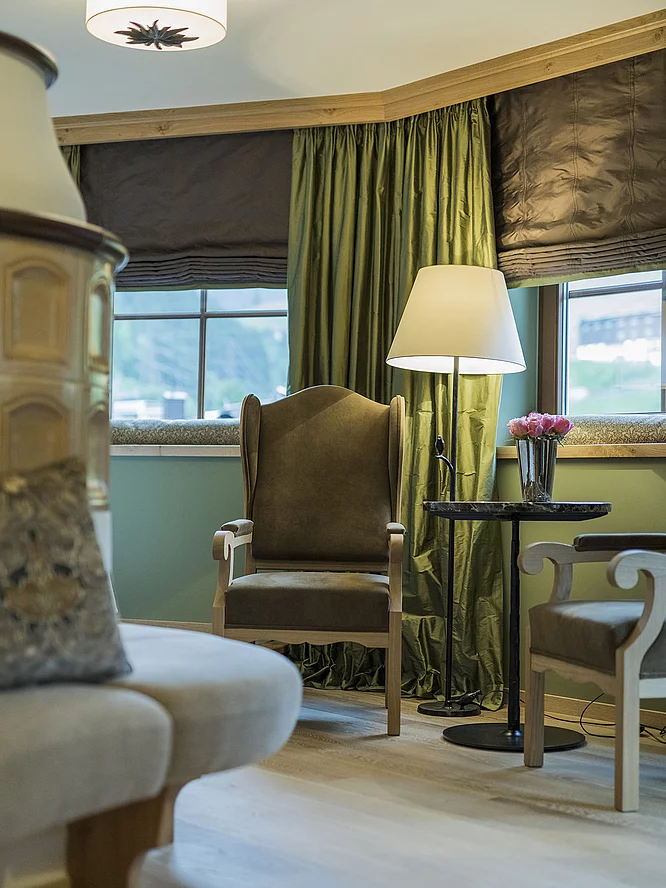 Zimmer & Suiten Stuhl mit Beistelltisch in der Familiensuite Deluxe im Hotel Unterschwarzachhof