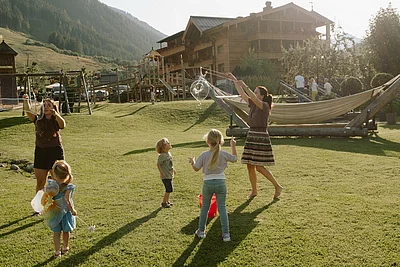Spielende Kinder mit Riesenseifenblasen auf der Wiese vor dem Hotel Der Unterschwarzachhof
