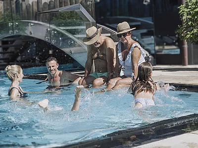 Familie mit Großeltern und Kindern im Pool des Familienhotels Unterschwarzachhof
