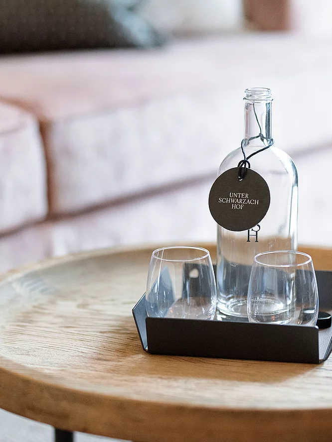 Inklusivleistungen Beistelltisch mit Glasflasche in der Familiensuite Deluxe im Hotel Unterschwarzachhof